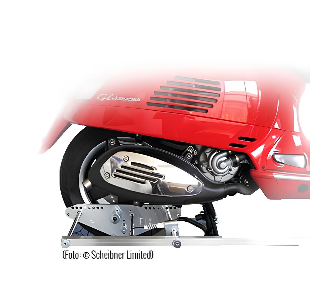 Hinterrad einer roten Vespa auf einem Prüfstand zur Achsvermessung von Zweirädern.